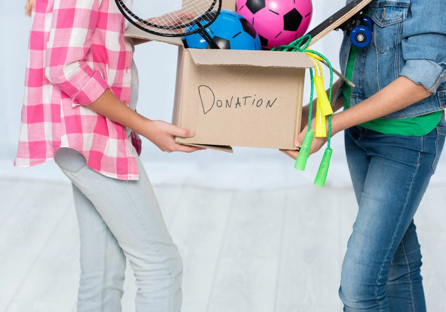 People holding a donations box with clothes, representing where to donate items in NYC